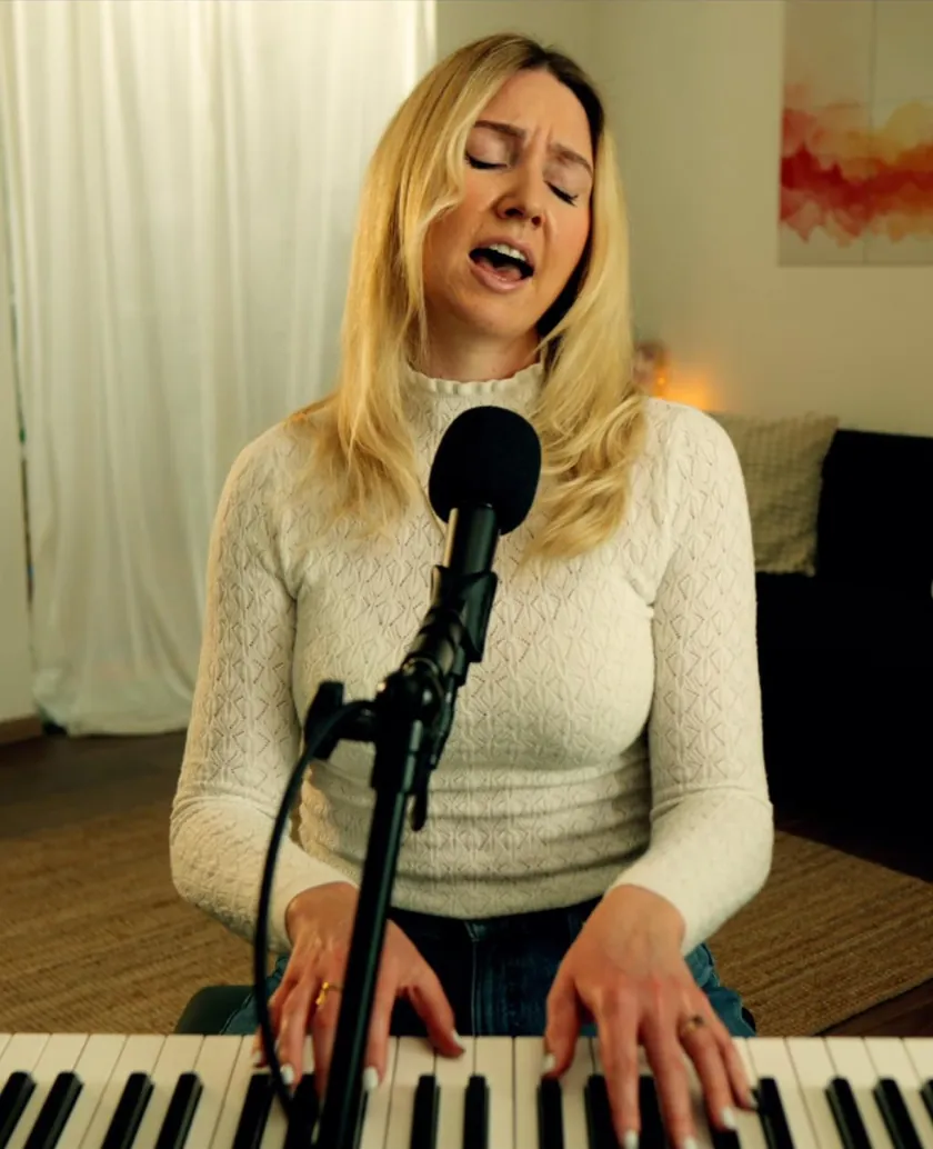 Kate Wand singing at the piano